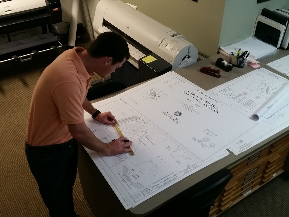 planning engineer working on plans and specs on drafting table